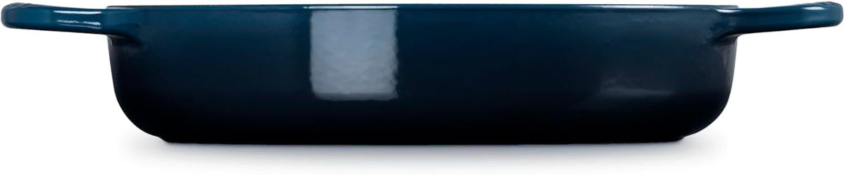 Side view of a dark blue rectangular baking dish with side handles, shown against a plain white background.