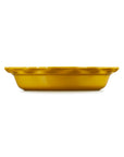 A small round yellow ceramic dish with a fluted rim, shown from a side profile against a solid white background.