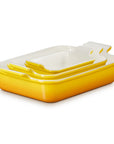 A set of three rectangular yellow baking containers, arranged in a nested stack on a white background.