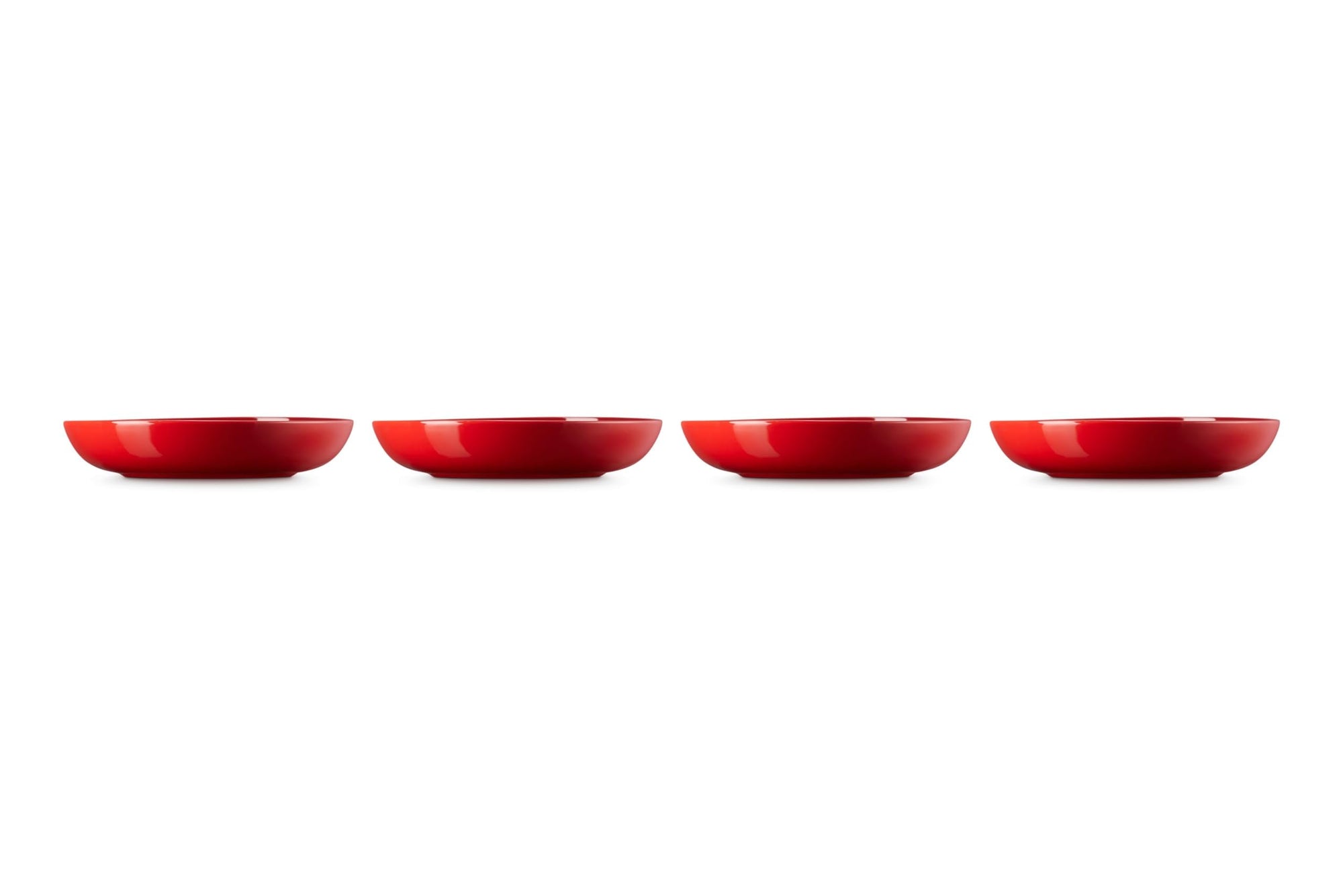 Four red ceramic bowls lined up on a white background