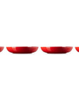 Four red ceramic bowls lined up on a white background