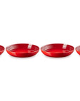 Four red ceramic bowls lined up on a white background