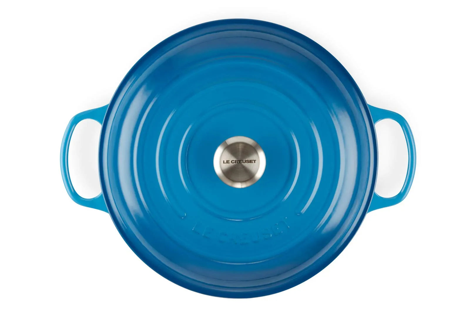 Top-down view of a Le Creuset round enameled cast iron pot with a matching blue lid, featuring side handles and a silver stainless steel knob in the center, set against a plain white background.