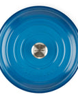 Top-down view of a Le Creuset round enameled cast iron pot with a matching blue lid, featuring side handles and a silver stainless steel knob in the center, set against a plain white background.