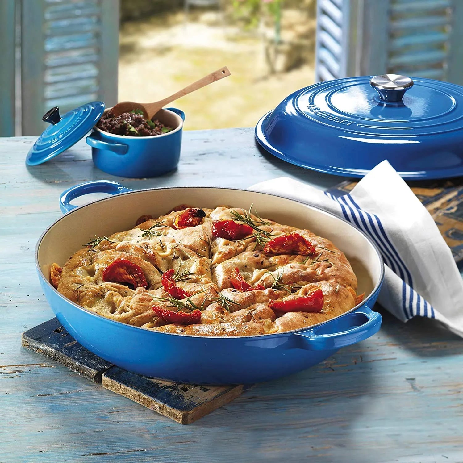 Blue cast iron skillet with baked dish on a wooden table