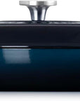 Side view of a dark navy blue enameled cast iron Dutch oven with a matching lid and side handles, featuring a silver knob on top, shown against a plain white background.