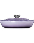 Purple enameled cast iron cookware with lid on a white background