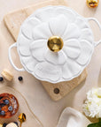 White ceramic mold with gold accents on a table with pastries and flowers