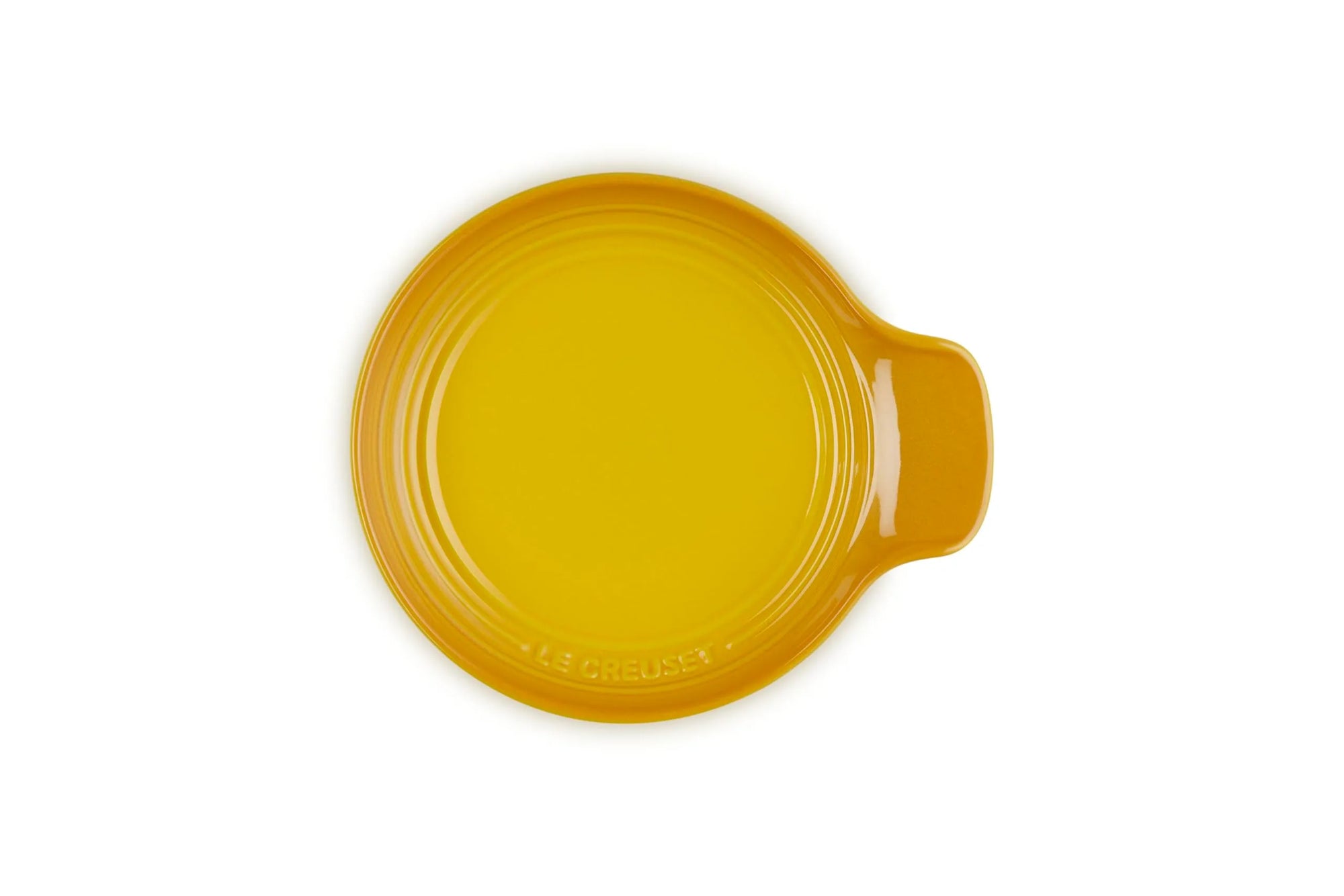 A round yellow ceramic spoon rest with a small side handle, photographed from directly above on a white background.