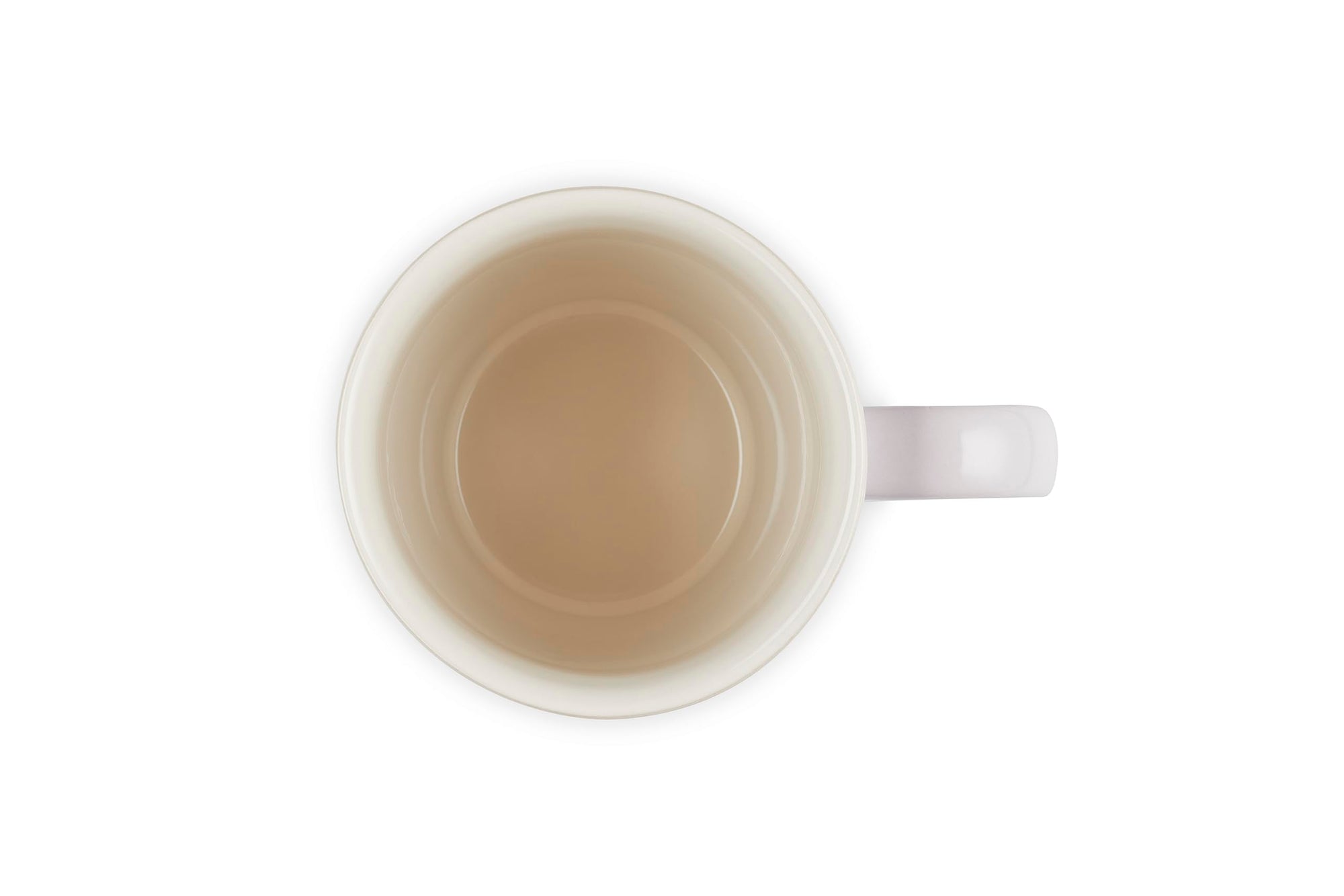 White mug with a small amount of brown liquid on a white background
