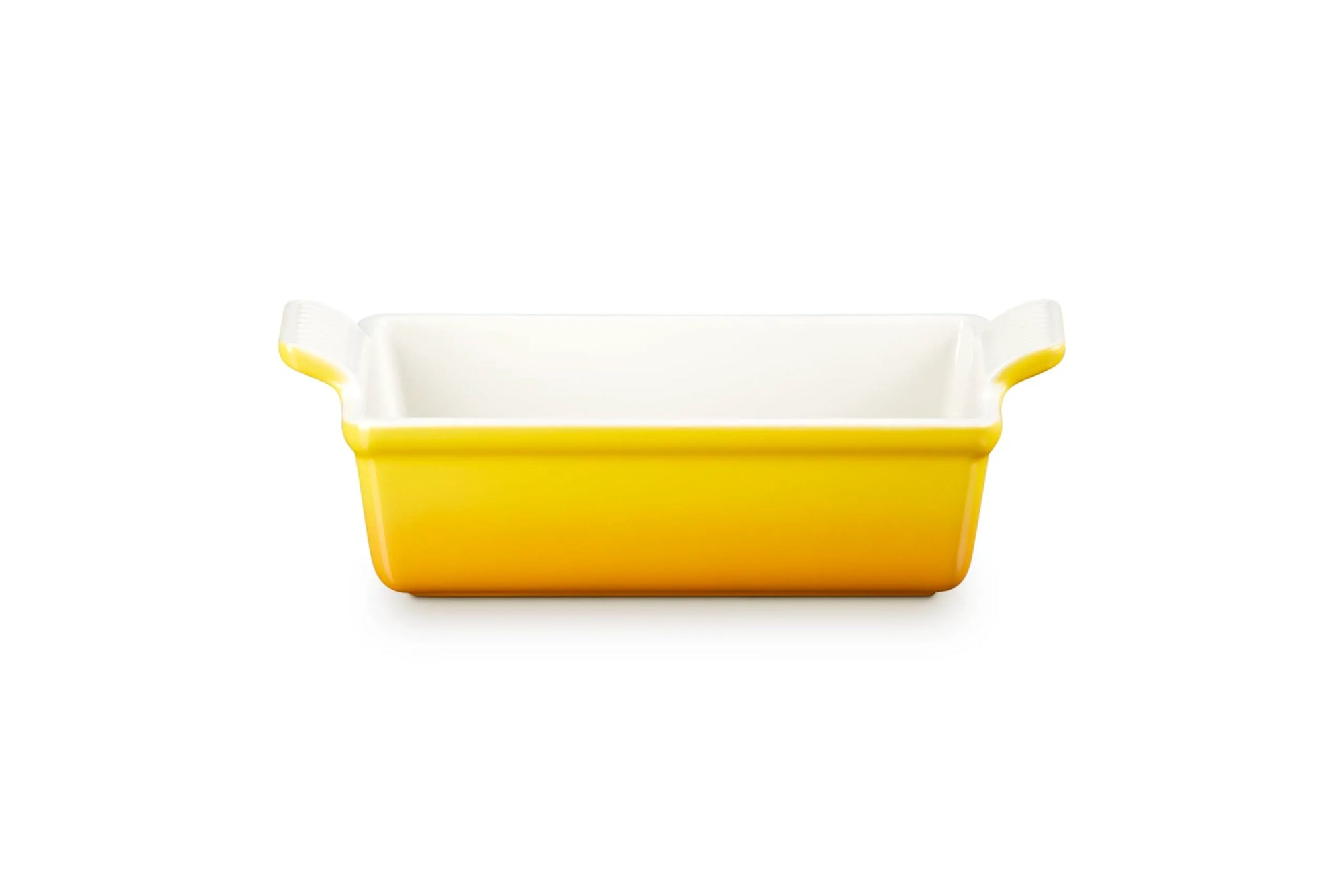 A rectangular ceramic baking dish with a bright yellow exterior and a white interior, featuring small side handles, shown on a plain white background.