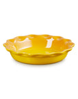 A bright yellow ceramic pie dish with a scalloped rim, shown on a clean white background.