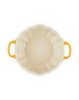 An oval ceramic baking dish with a cream-colored interior and bright yellow-orange handles, shown from a top-down view on a white background.