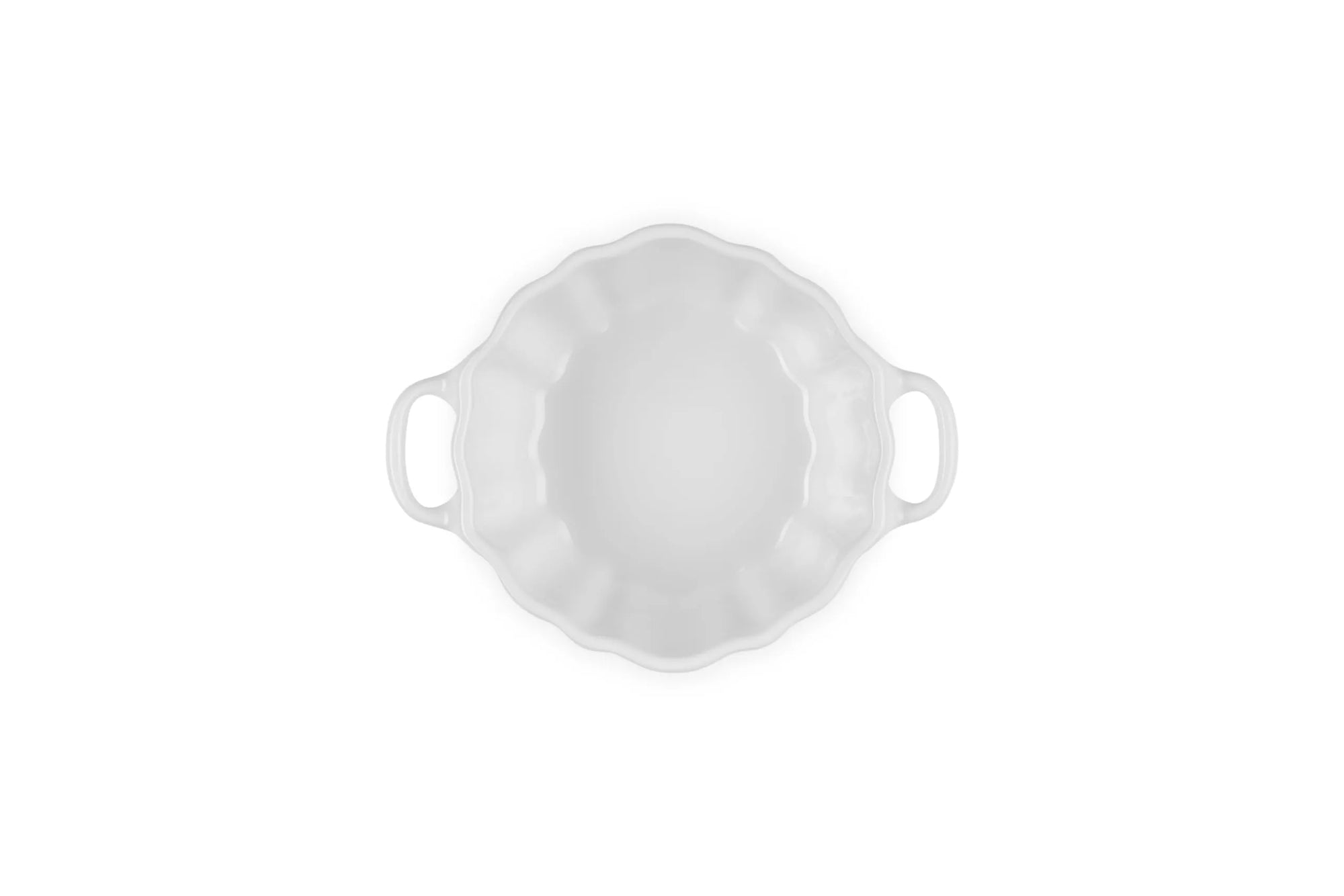A white ceramic baking dish with a scalloped rim and two side handles, shown from a top-down view on a solid white background.