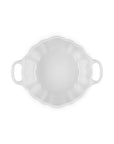 A white ceramic baking dish with a scalloped rim and two side handles, shown from a top-down view on a solid white background.
