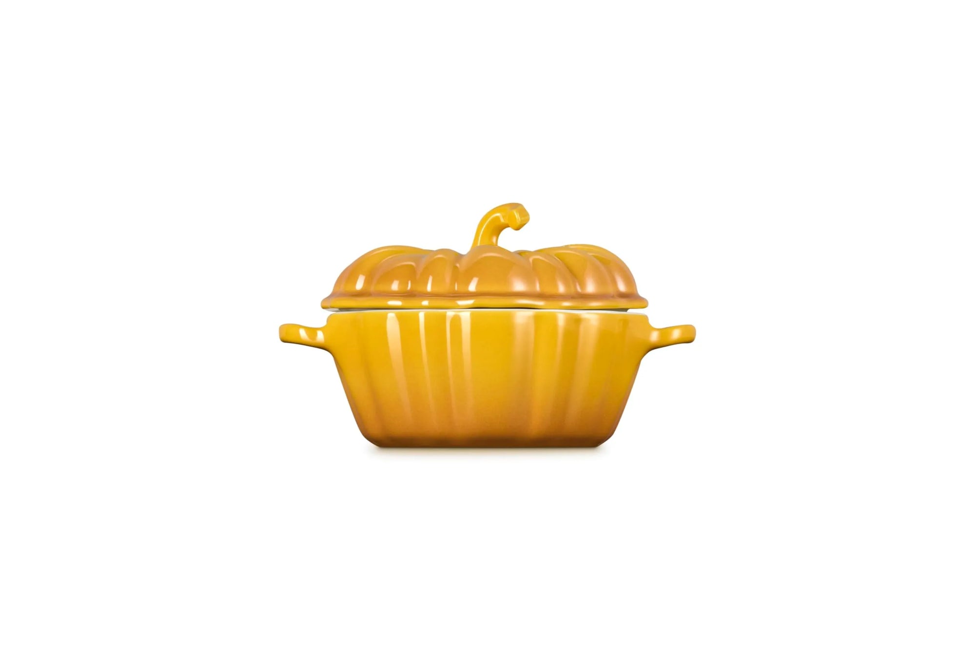 A yellow-orange pumpkin-shaped ceramic casserole dish with a matching lid and small side handles, centered on a plain white background.