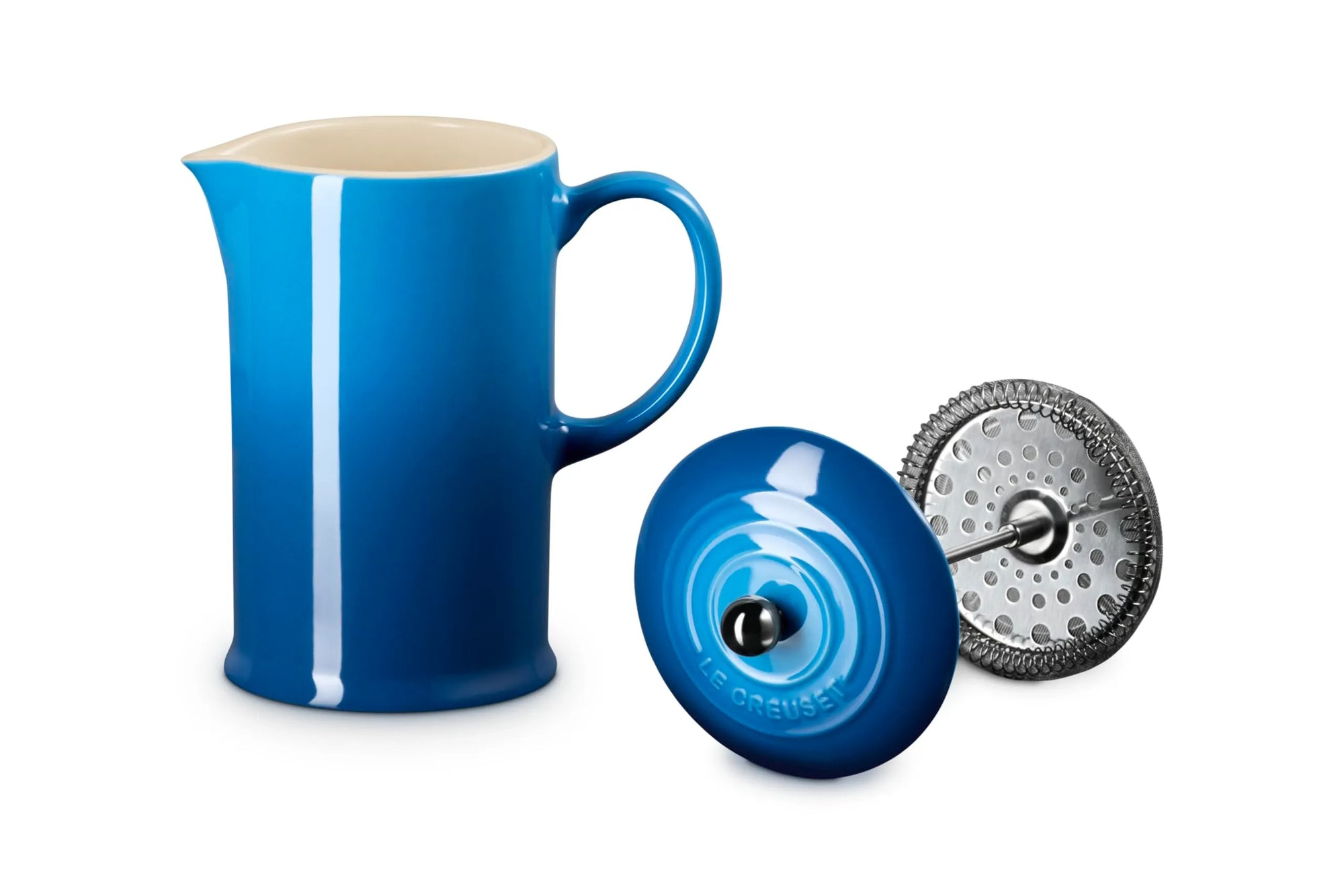 A vibrant blue coffee French press with a cream-colored interior, shown alongside its black lid and a silver metal infuser filter on a clean white background.