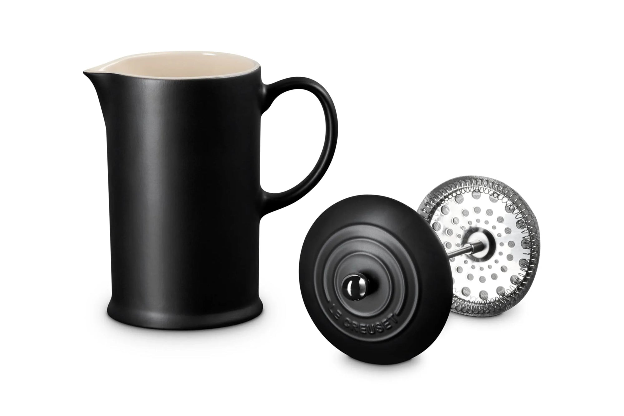 A matte black coffee french press with a cream-colored interior, shown alongside its black lid and a silver metal infuser filter on a clean white background.