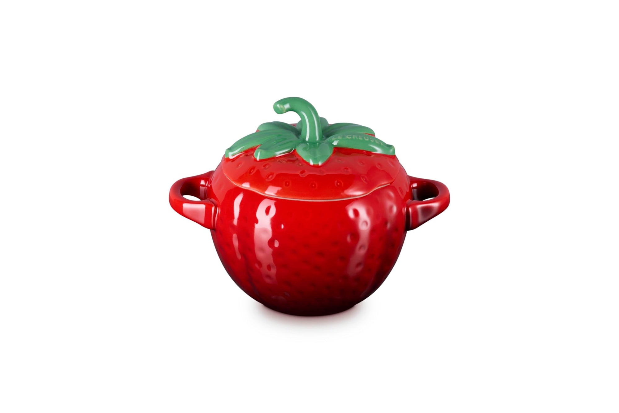 Side view of red ceramic pot shaped like a strawberry with green stem lid on a white background