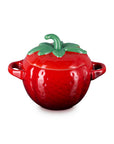 Side view of red ceramic pot shaped like a strawberry with green stem lid on a white background