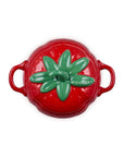 Top view of red ceramic pot shaped like a strawberry with green stem lid on a white background