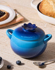 Blue Le Creuset pot on a table with bread and berries
