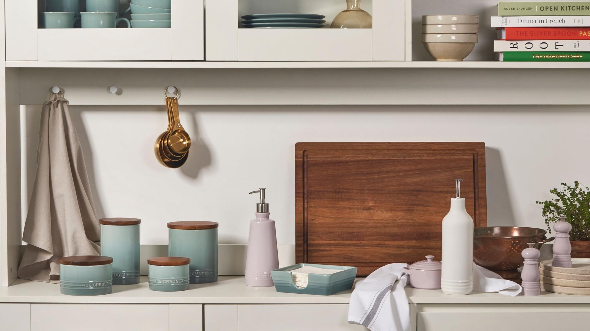 Le Creuset products on a kitchen counter in a kitchen setting