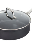 Black frying pan with a glass lid on a white background