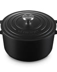 Black cast iron round oven with a lid and handles displayed on a white background