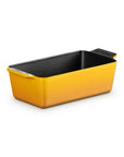 A rectangular loaf pan with a bright yellow exterior and a black textured interior, shown on a clean white background.