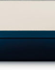 A rectangular baking dish with a deep blue exterior and a cream-colored interior, featuring two side handles.