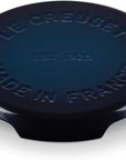 A dark blue Le Creuset round trivet with embossed text reading 'LE CREUSET', 'EST 1925', and 'MADE IN FRANCE', shown on a white background.