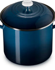 A dark blue enameled cast iron stockpot with a matching lid and side handles, shown on a clean white background.