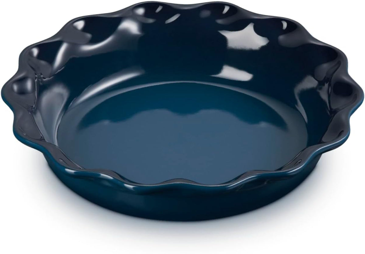 A dark navy blue ceramic pie dish with a fluted, scalloped rim, shown on a clean white background.