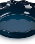 A dark navy blue ceramic pie dish with a fluted, scalloped rim, shown on a clean white background.