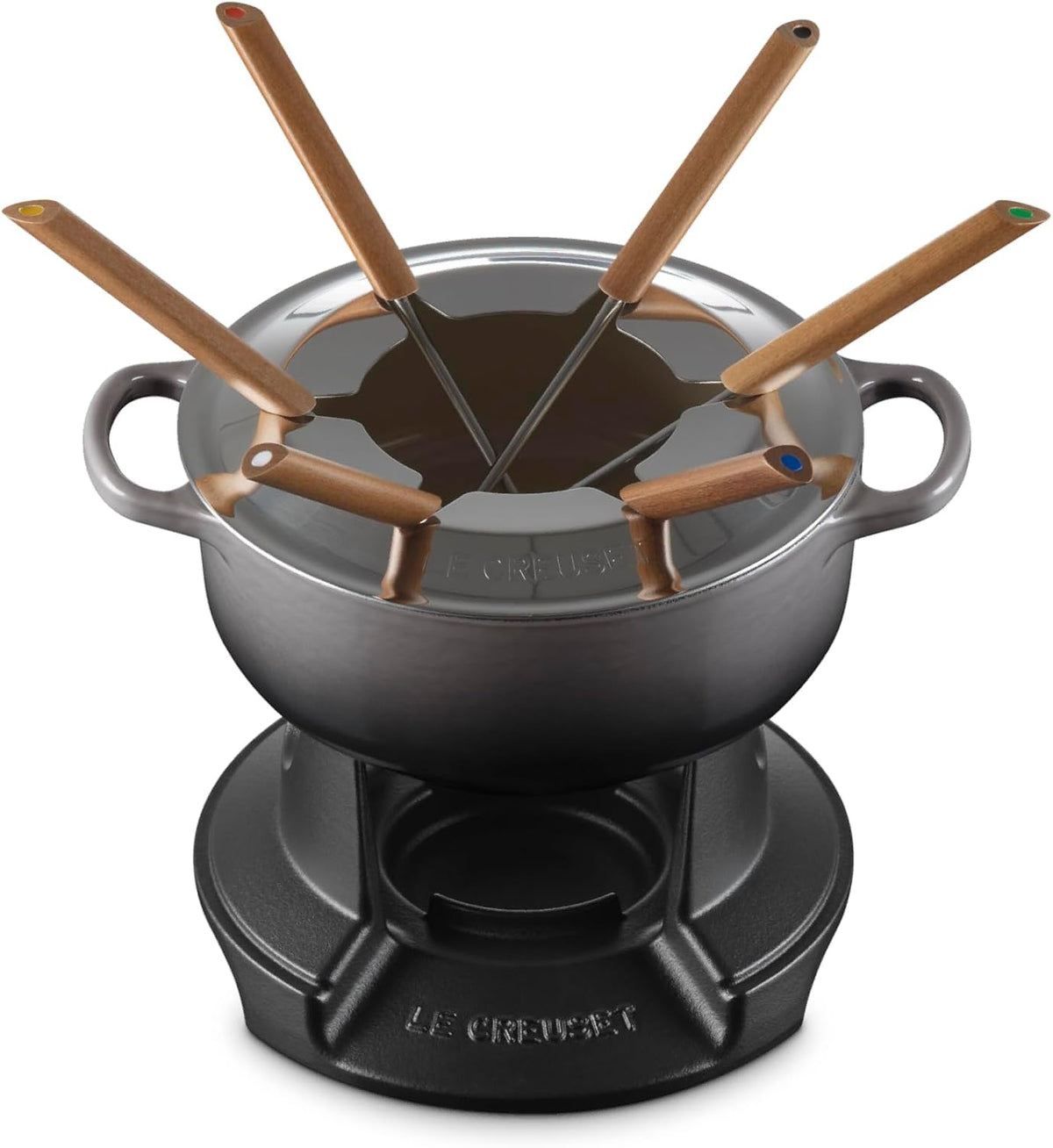 A Le Creuset fondue pot set on a matching black base, with six wooden-handled utensils arranged around the pot on a white background.