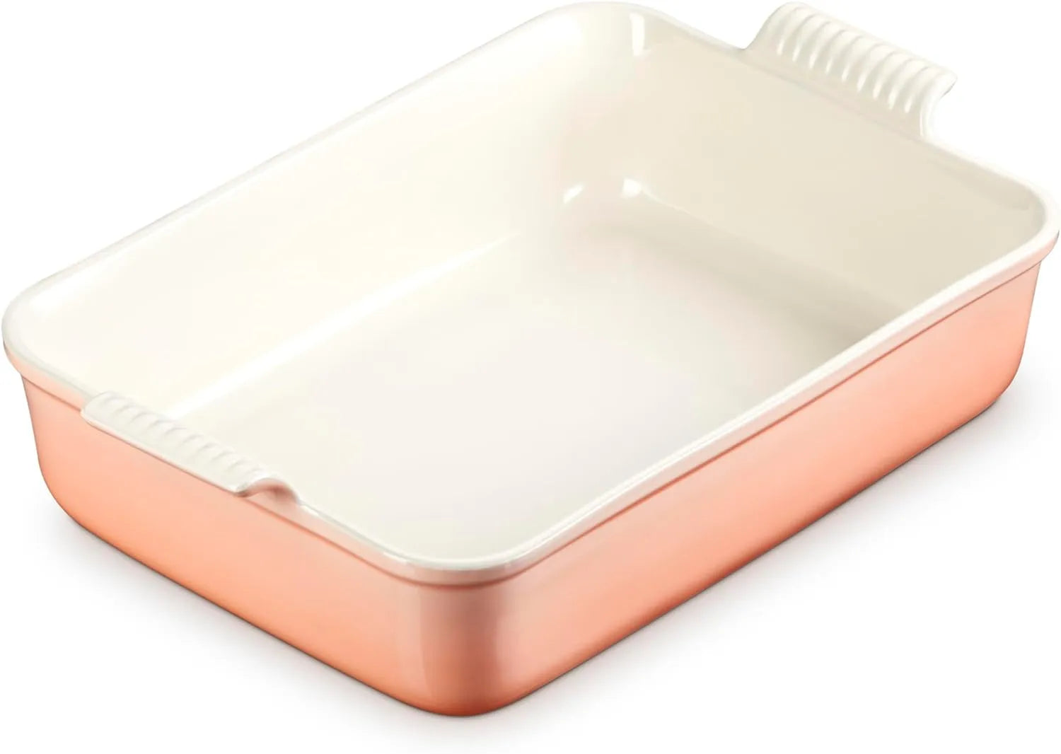 A rectangular ceramic baking dish with a peach exterior and a cream-colored interior, featuring integrated side handles with a ribbed texture.