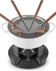 Le Creuset fondue set with a white ceramic pot, black cast-iron base, and six copper-colored wax melting wicks with dark handles, shown on a white background.