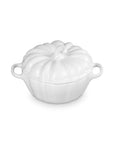 A white cast iron pumpkin-shaped lidded cocotte dish with side handles, shown on a solid white background.