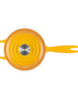 A bright yellow enameled cast iron Dutch oven with a matching lid, featuring a long handle and a small side loop, photographed from directly above on a white background.