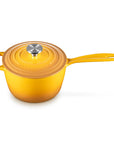 A bright yellow enameled cast iron saucepan with a matching lid and a silver knob, shown on a clean white background.