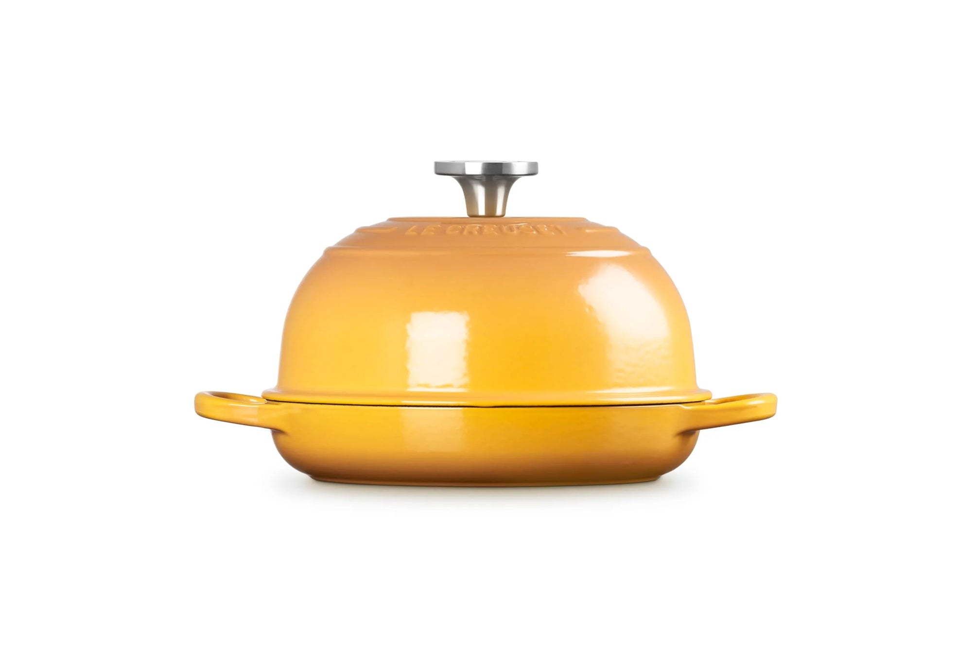 A yellow enameled cast iron casserole dish with a matching lid and side handles, photographed on a clean white background.
