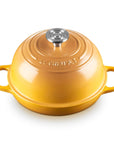 A yellow Le Creuset enameled cast iron pot with a matching lid, featuring side handles and a silver knob, set against a plain white background.