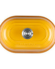 Top-down view of a yellow enameled cast iron Dutch oven with a matching lid, featuring side handles and a stainless steel knob, on a white background.