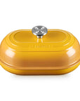 A yellow Le Creuset lidded casserole dish with side handles and a silver knob, shown on a clean white background.