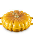 A yellow pumpkin-shaped enameled cast iron Dutch oven with two side handles and a matching lid, shown on a solid white background.