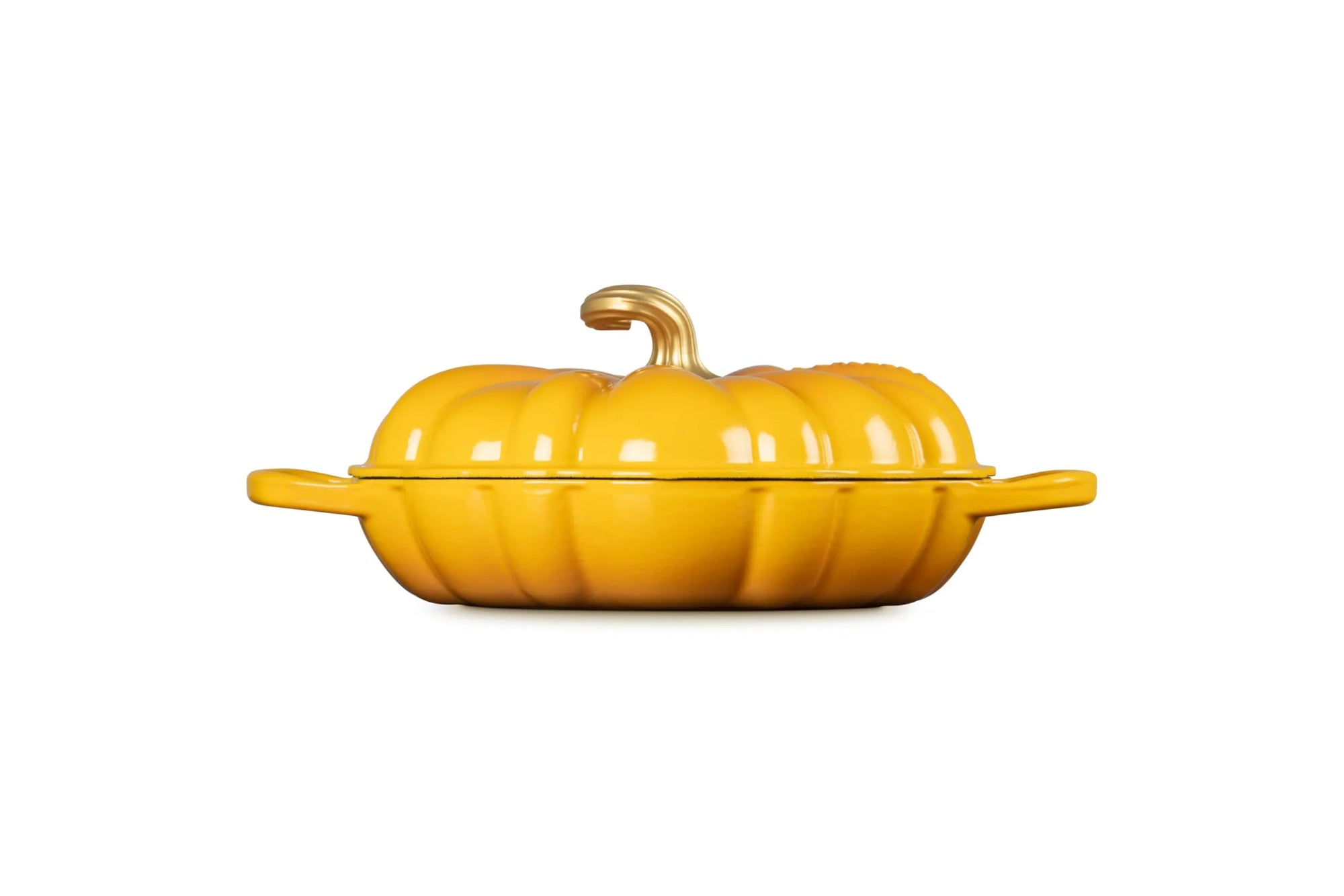 A bright yellow pumpkin-shaped lidded casserole dish with side handles and a small stem on top, photographed against a plain white background.