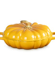 A bright yellow pumpkin-shaped enameled cast iron Dutch oven with a matching lid and side handles, shown on a clean white background.
