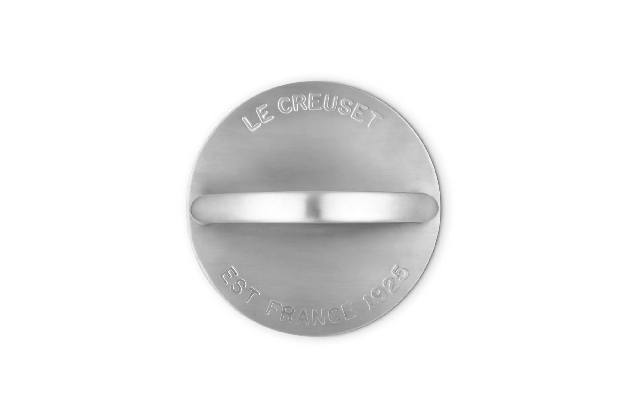 Top view of a circular silver-toned metal grill press with a horizontal center bar and engraved text reading 'LE CREUSET' and 'EST FRANCE 1925' on a plain white background.