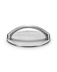 A Le Creuset round grill press with a semi-circular handle, featuring engraved 'LE CREUSET' and 'EST FRANCE 1925' text, shown on a clean white background.